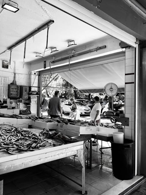 Schwarzweißansicht eines Fischmarkts auf Kreta mit Auslage und Kunden