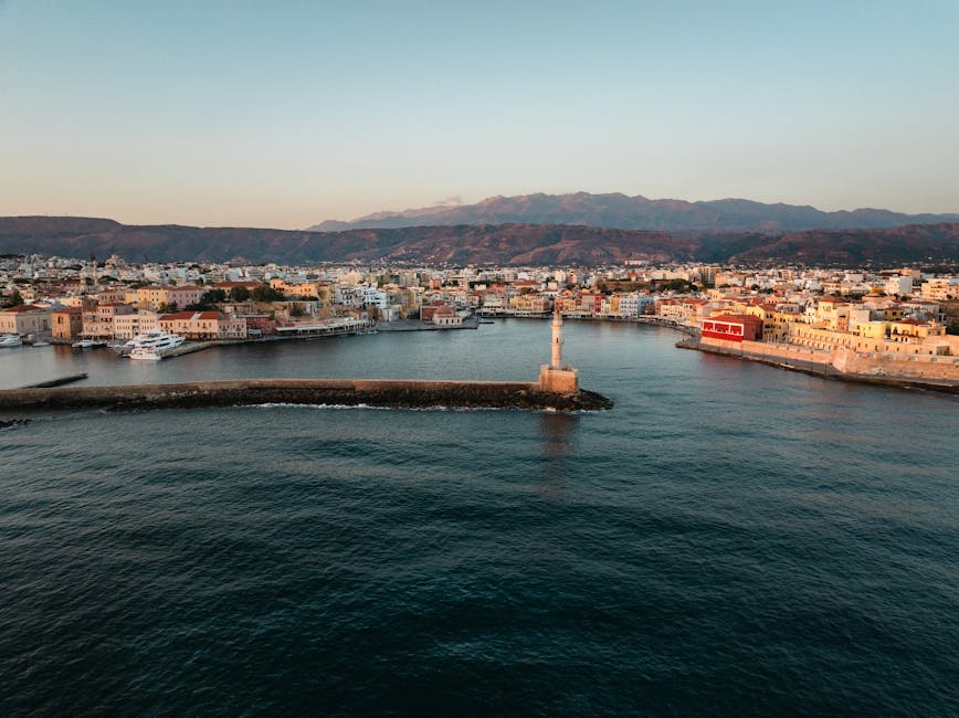 Havenstad op Kreta met vuurtoren en bergen op de achtergrond