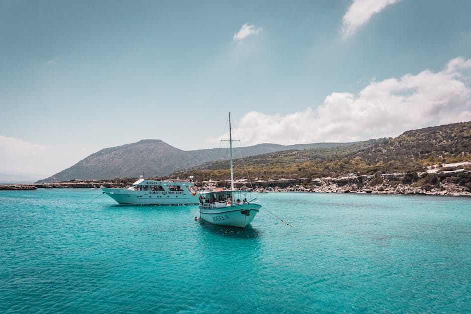 Twee boten ankeren in turquoise water voor rotsachtige kust van Kreta