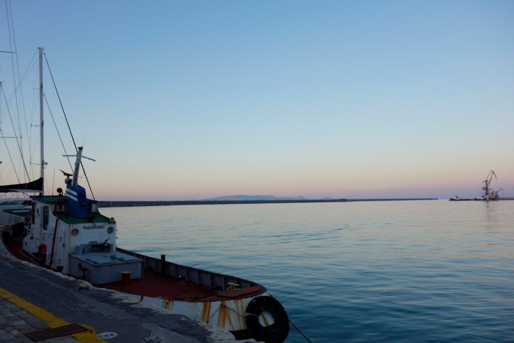 Een vissersboot aangemeerd in een rustige haven op Kreta bij schemering