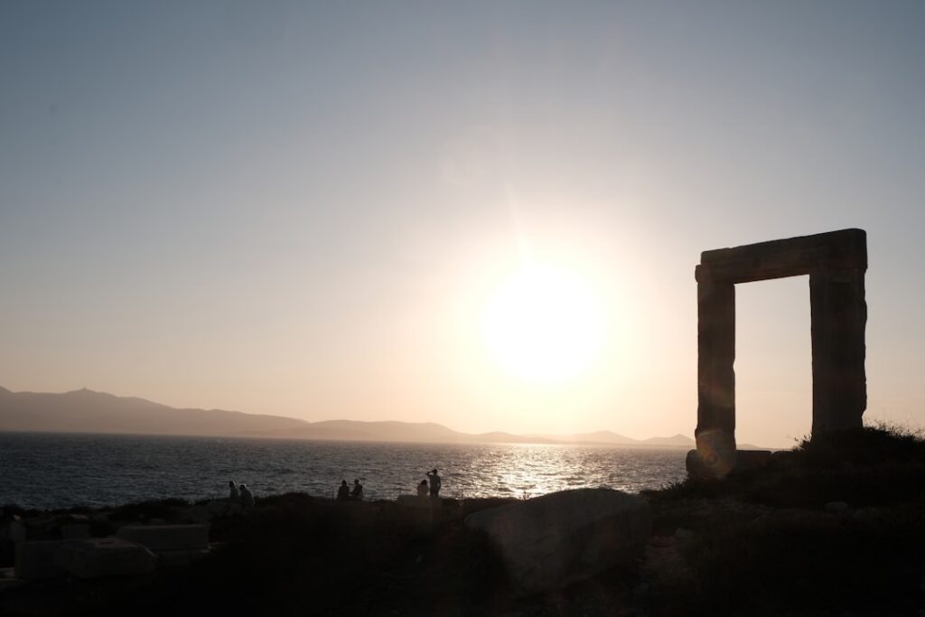 Portail antique silhouetté au coucher de soleil sur la côte crétoise