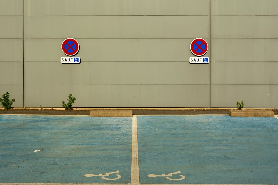 Dwa niebieskie miejsca parkingowe dla niepełnosprawnych przy ścianie