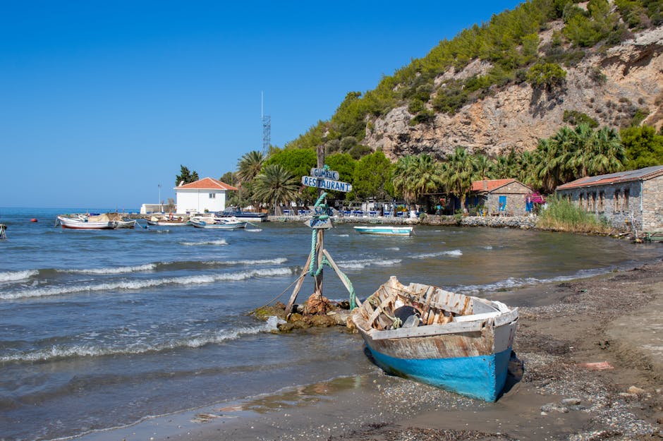 Rustige kustbaai op Kreta met verweerde houten boot en restaurantjes