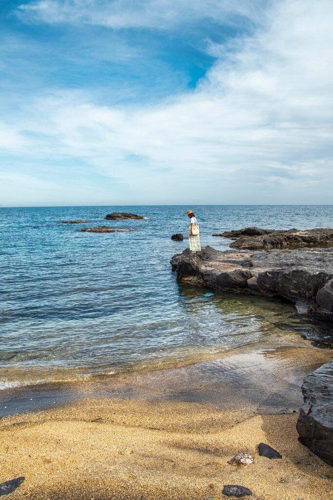 Persoon op rotsen bij een stille baai op Kreta
