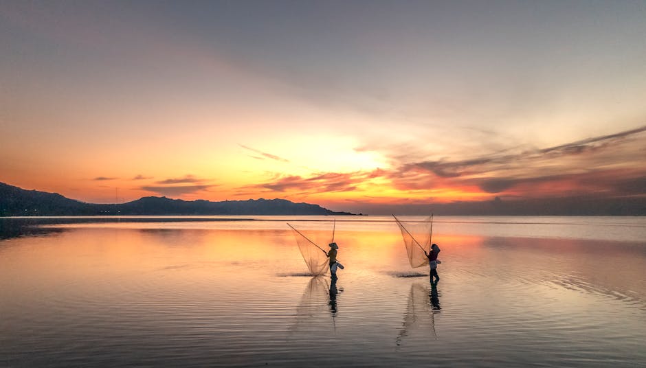 Deux pêcheurs lançant leurs filets au coucher de soleil en Crète