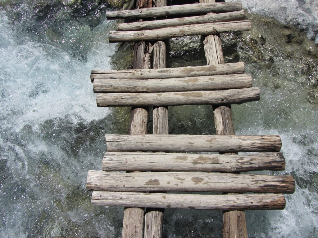 Smalle houten brug van ruw hout boven kolkend bergwater in de Samaria-kloof