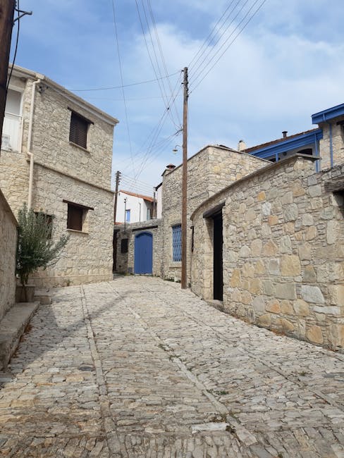Ruelle pavée et maisons en pierre aux portes bleues d'un village crétois