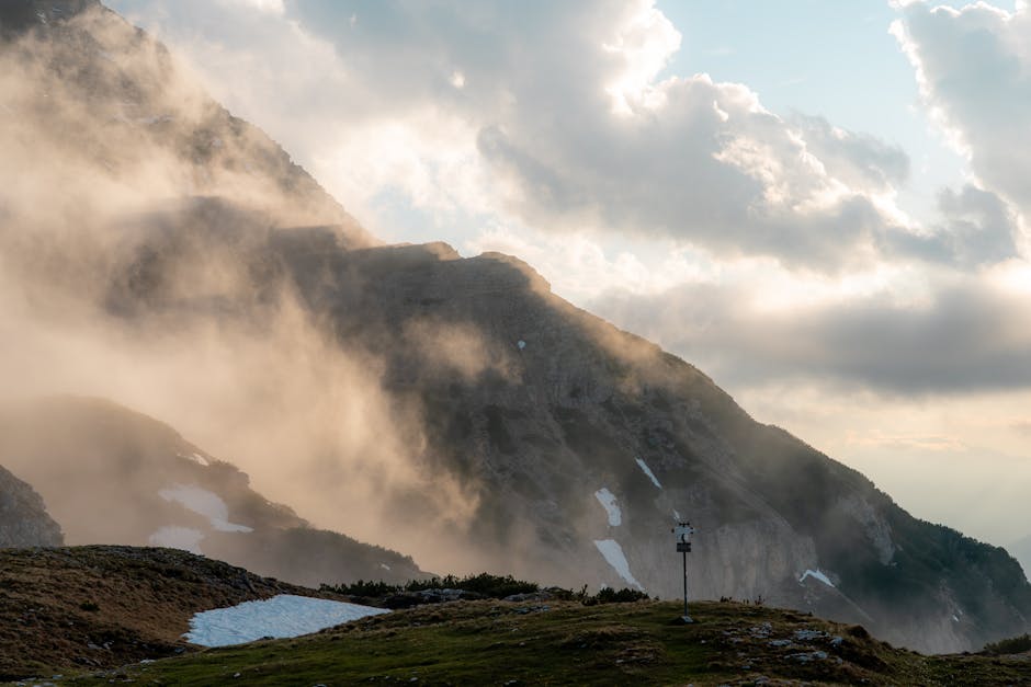 Mistige bergflank met sneeuwvelden en een weerstation in Kreta