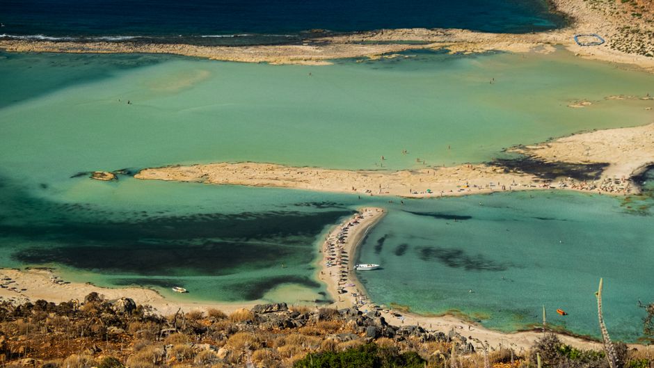 Lagune turquoise avec tombolo sableux et baigneurs, vue aérienne en Crète
