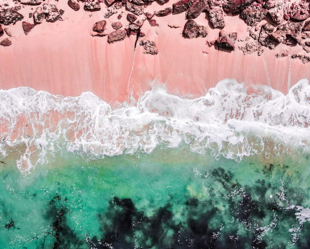 Plage au sable rose, vagues turquoises vues du ciel en Crète