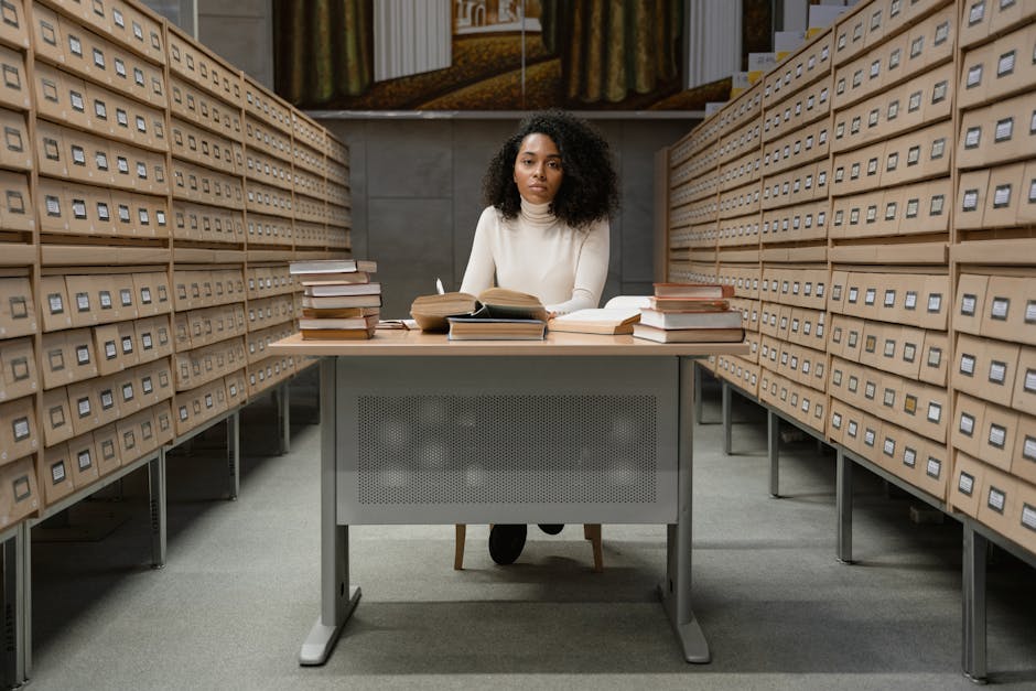 Onderzoeker zittend aan bureau tussen archiefdozen in archiefcentrum op Kreta