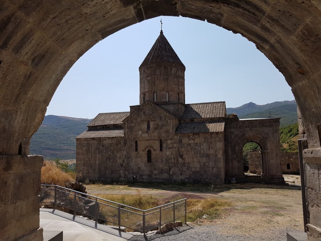 Middeleeuwse stenen kerk gezien door boog, landschap op de achtergrond op Kreta
