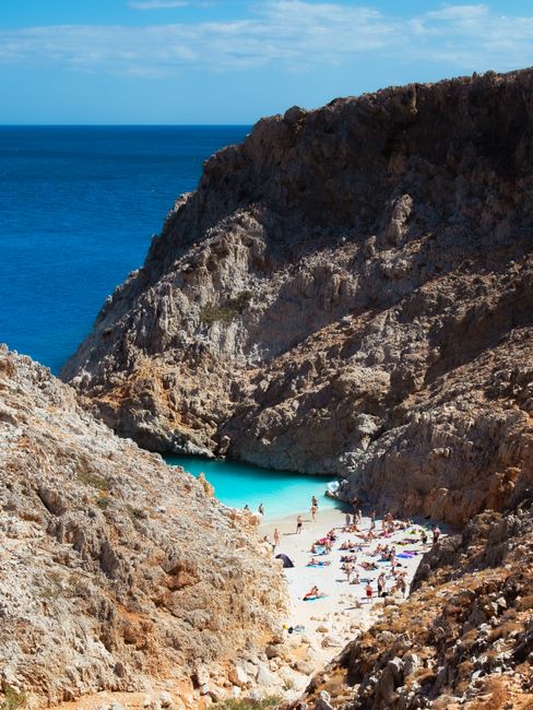Kleine verborgen baai op Kreta met turquoise water en zonaanbidders