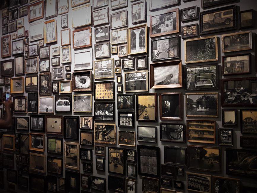 Mur couvert de centaines de photos encadrées, archives visuelles de Crète