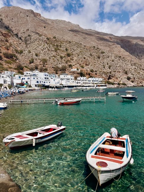 Traditioneel wit dorp aan helder water met bootjes in Kreta