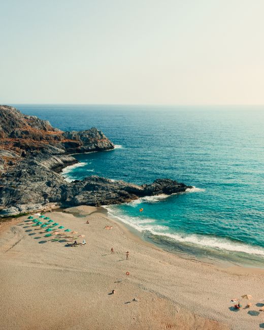Klein zandbaaitje met blauw water Korfos bij Heraklion