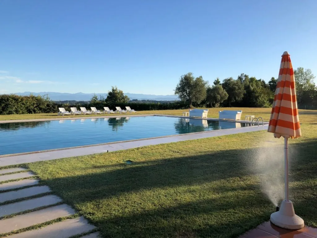 Piscine extérieure entourée de transats et vue sur la campagne siennoise