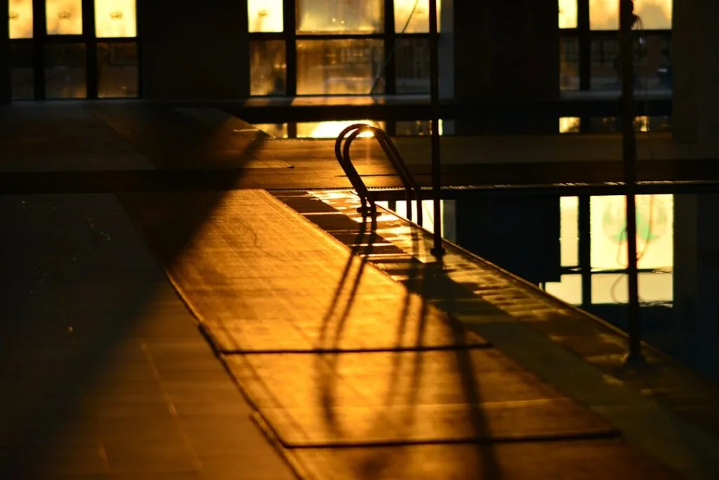 Bord de piscine intérieure du spa, reflets dorés au coucher