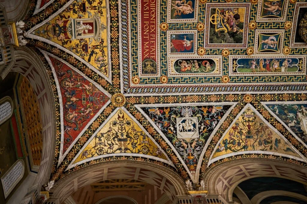 plafond peint richement du Duomo de Sienne aux panneaux dorés