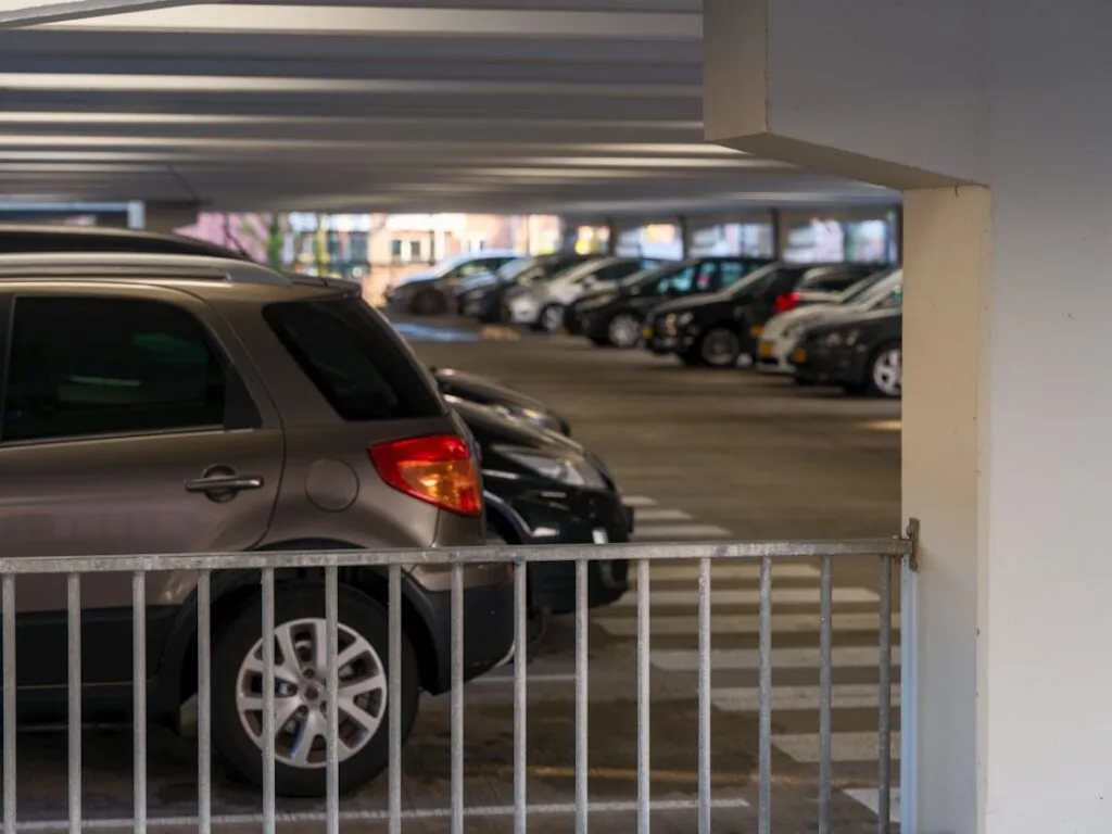 Intérieur d'un parking couvert avec rangée de voitures garées
