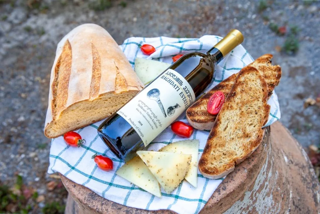 Pique-nique rustique: pain, vin, fromage et tomates sur torchon