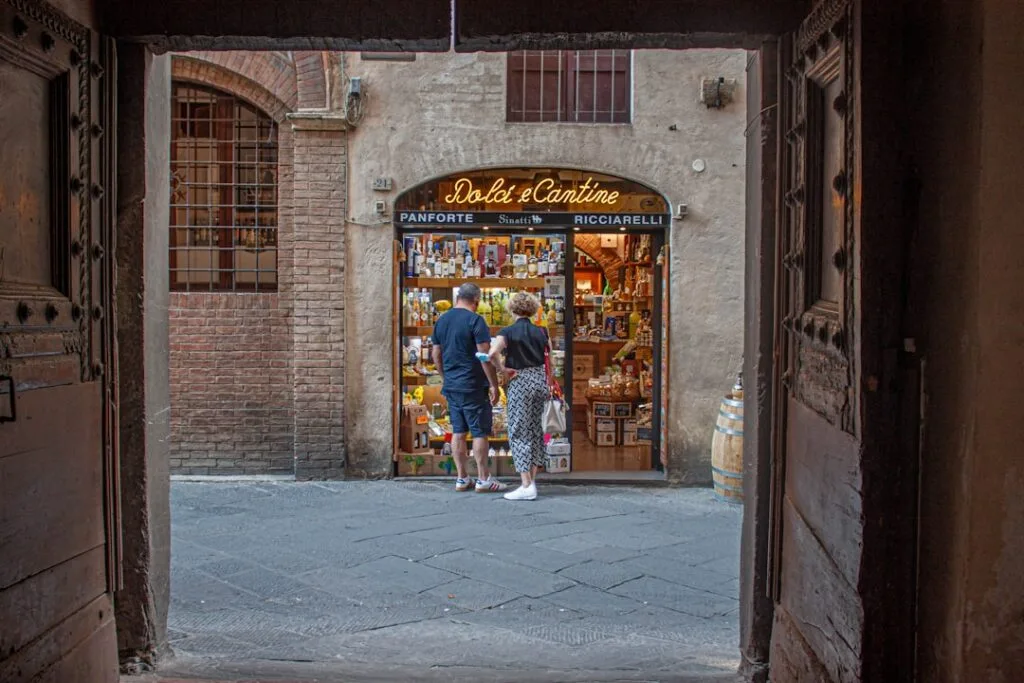 Koppel kijkt naar etalage van een ambachtelijke levensmiddelenwinkel in Siena