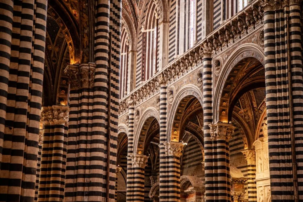 Innenraum des Doms in Siena mit schwarz-weißen Säulen und Bögen
