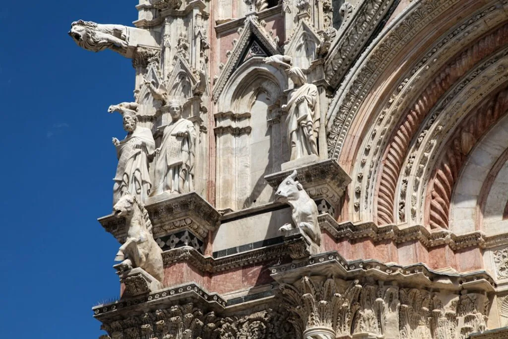 Détails sculptés de la façade du Duomo de Sienne sous ciel bleu
