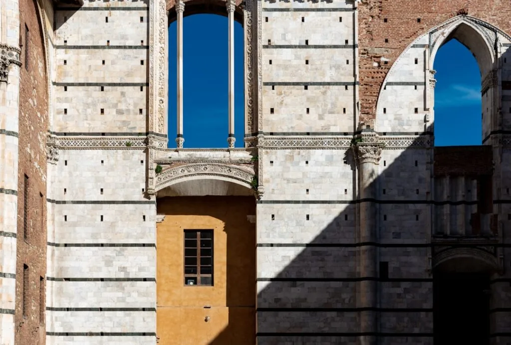Weißer Marmor mit schwarzen Streifen, gelbes Fenster und Schatten in Siena.