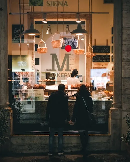 Couple debout, mains jointes devant une boulangerie à Sienne