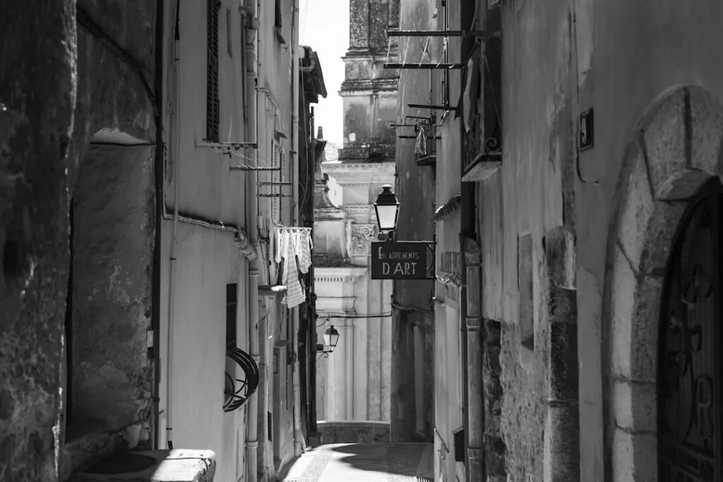 Ruelle étroite en noir et blanc, linge aux fenêtres et enseigne