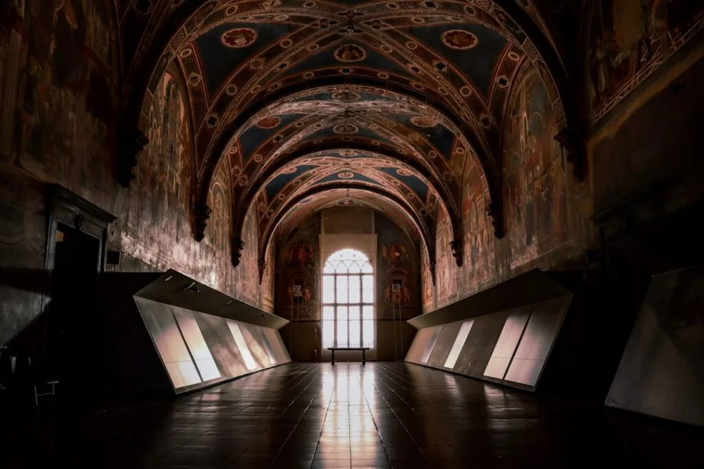 Salle intérieure sombre du Palazzo Pubblico avec voûtes peintes