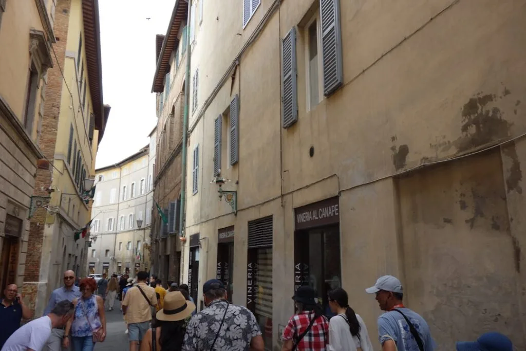 Rue étroite à Sienne animée de touristes et boutiques