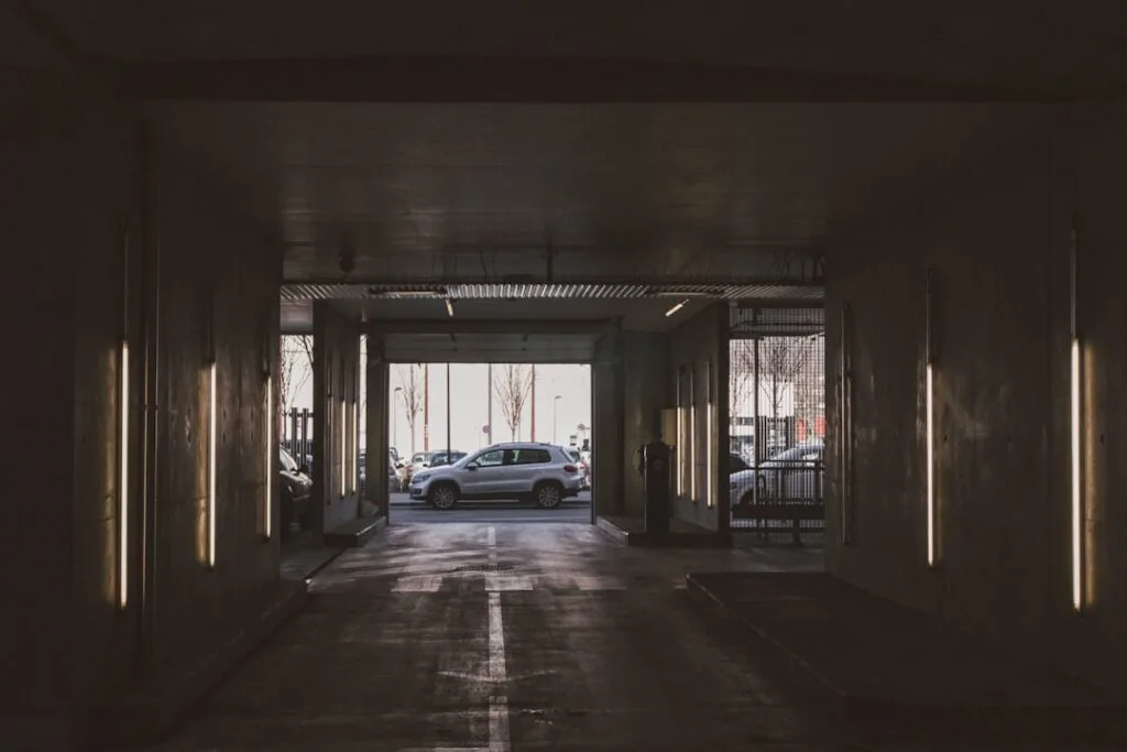 Sortie sombre d'un parking souterrain avec voiture visible à l'extérieur