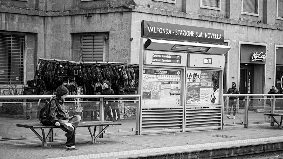 Black-and-white platform at Florence Stazione S.M. Novella with waiting passenger.