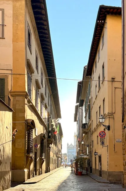 Rue étroite pavée à Sienne, vue vers la cathédrale au loin