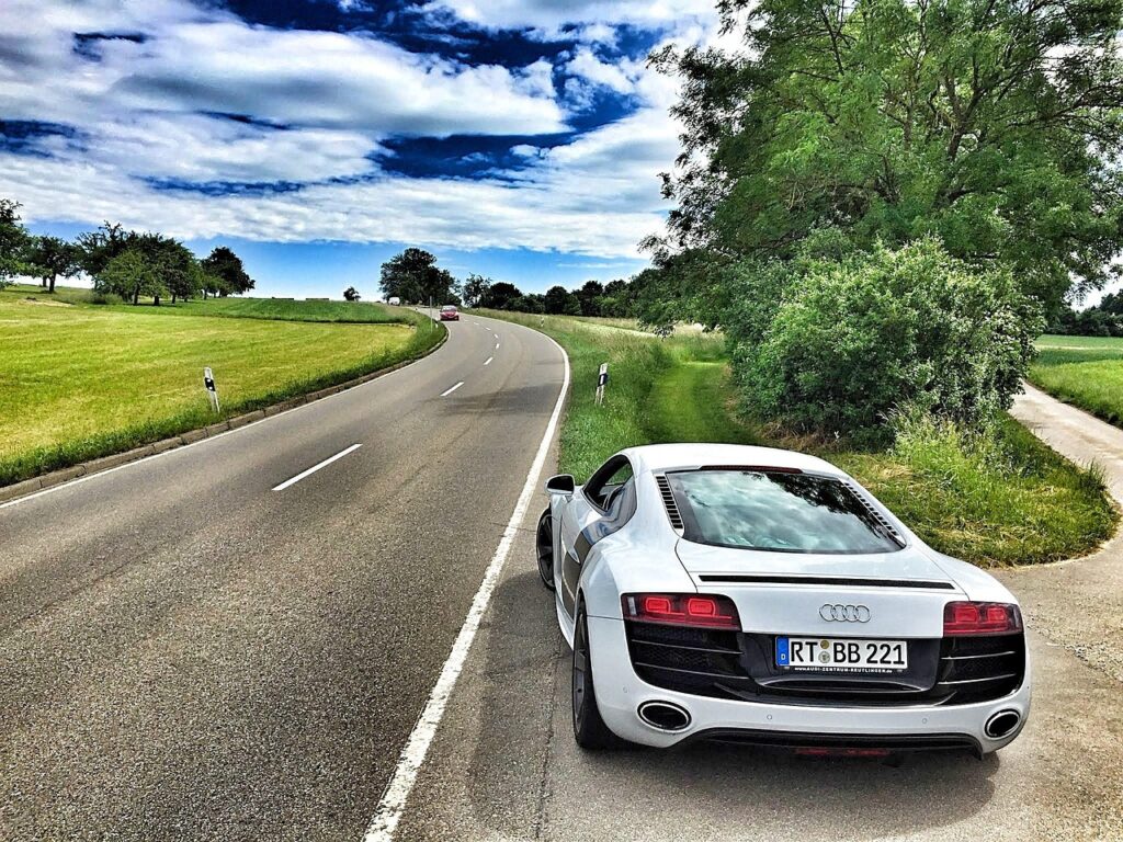 White Audi sports car parked beside winding country road near Siena.