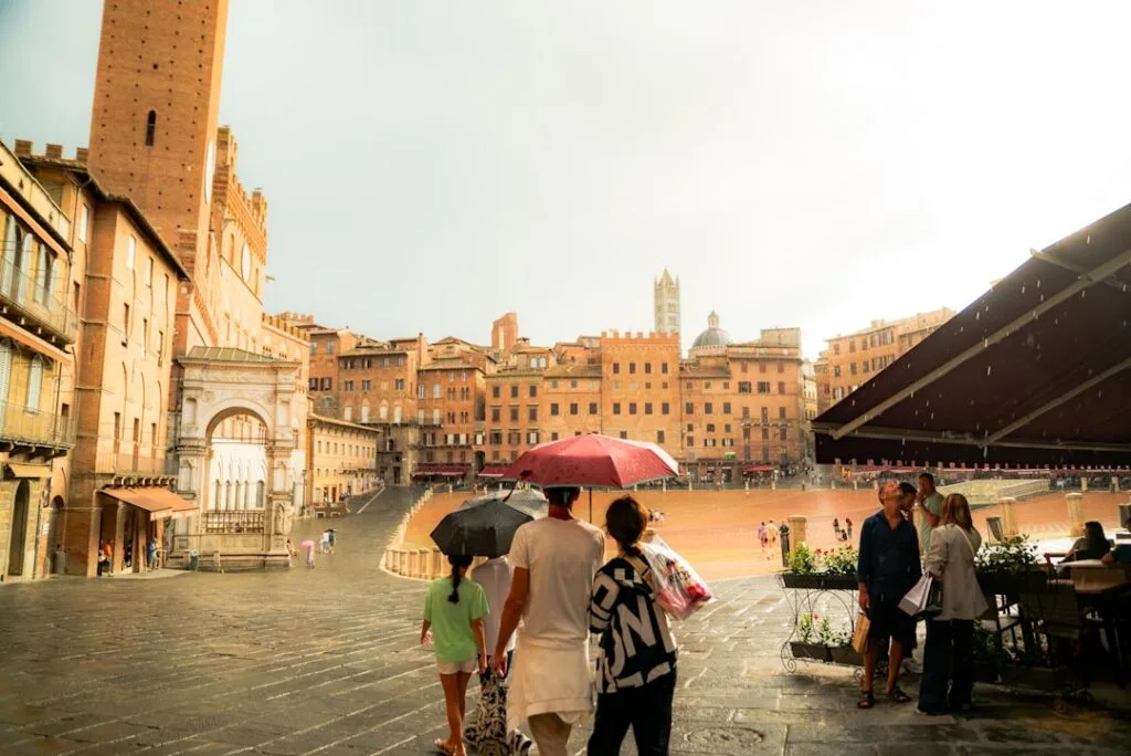 Visiteurs sous parapluies sur la Piazza del Campo mouillée à Sienne