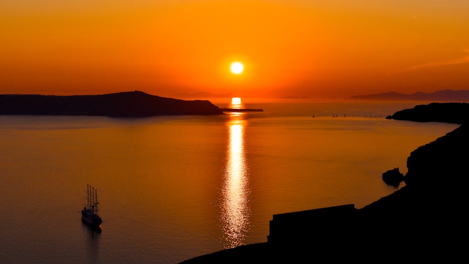 Vista del tramonto su Oia vista da un catamarano nella caldera di Santorini