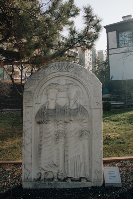 Marble funerary stele showing two draped figures displayed outdoors in Rhodes
