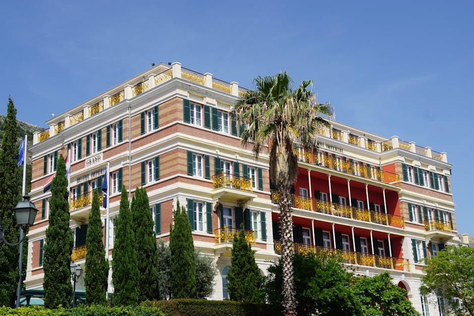 Prächtiges historisches Hotelgebäude mit Balkonen und Palmen am Ufer von Rhodos