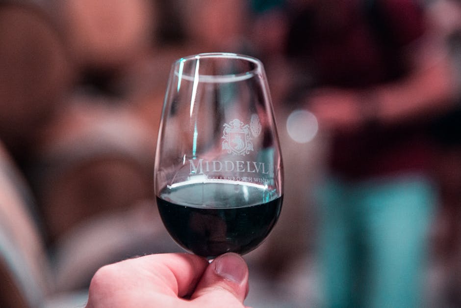 Main tenant un verre de vin rouge lors d'une dégustation à Rhodes