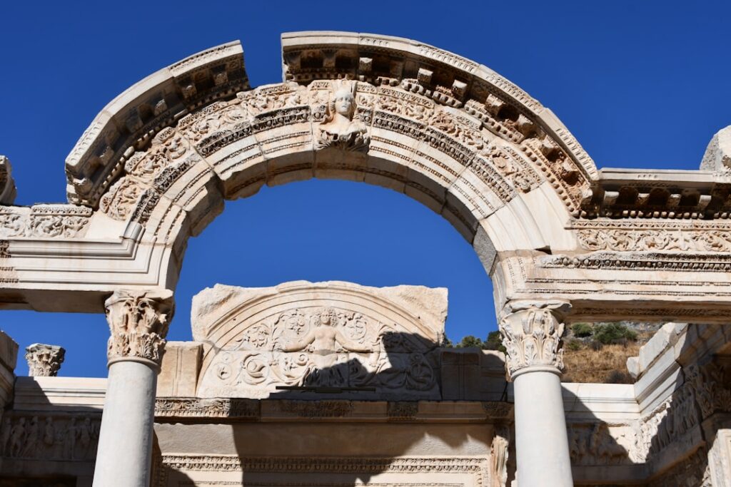 Arco marmoreo decorato con rilievi contro cielo blu a Rodi