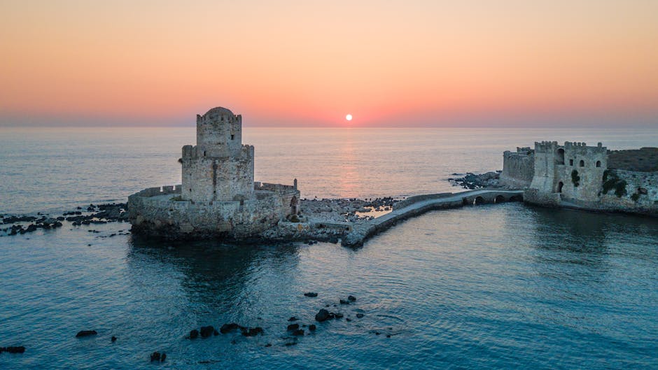 Torre fortificata su isolotto collegata da passerella al tramonto sul mare