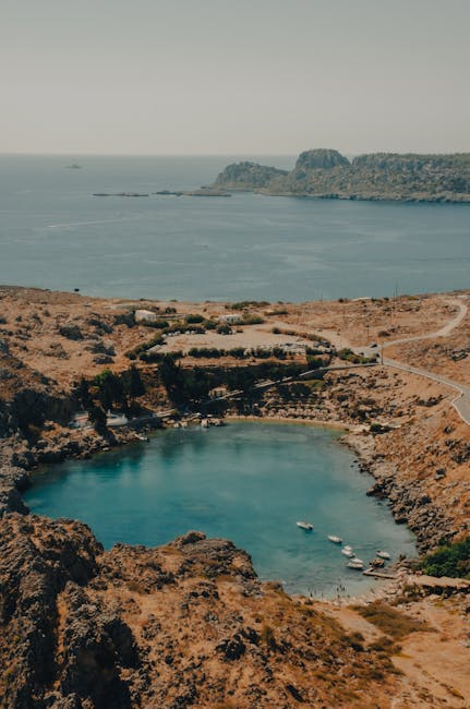 Türkisfarbene Bucht mit Booten und felsiger Küste auf Rhodos