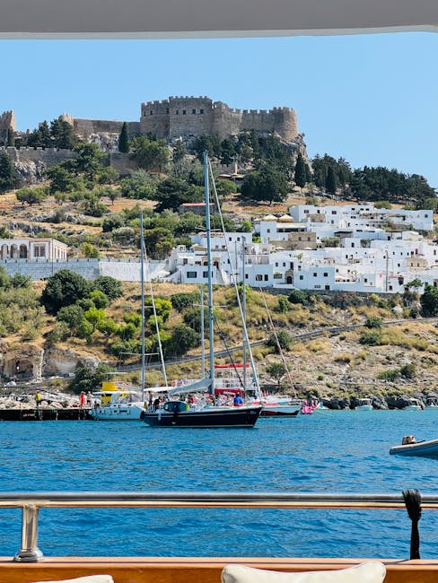 Blick vom Boot auf Segelboote und die Burg über weißen Häusern auf Rhodos