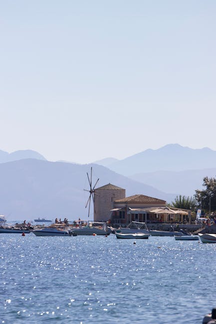 Windmühle am Ufer mit Booten und Bergen im Hintergrund auf Rhodos