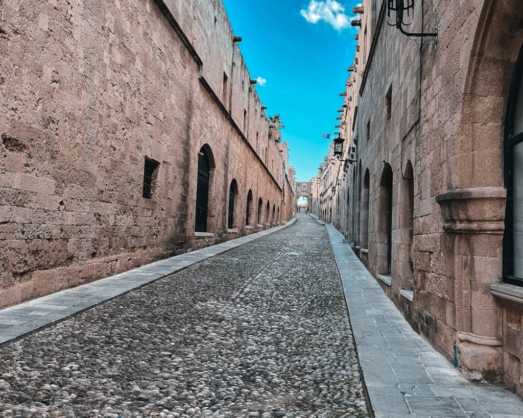 Vicolo lastricato con alte mura medievali nella città vecchia di Rodi