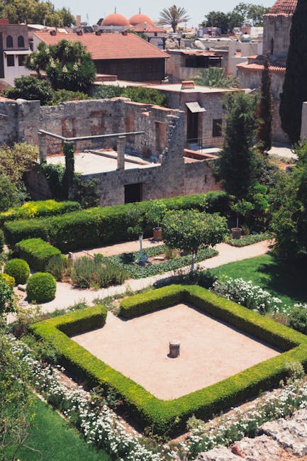 Formal walled garden in Rhodes with trimmed hedges and ancient ruins