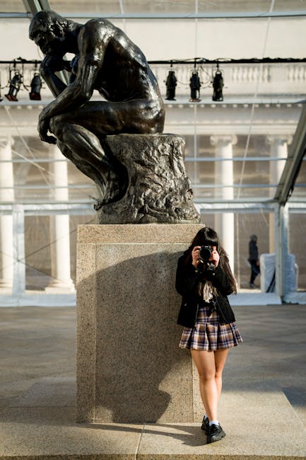 Persona con macchina fotografica accanto a grande scultura nel Museo di Rodi